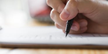 Hand with pen over application form