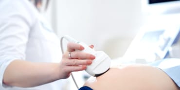 Doctor performing ultrasound scanning for her pregnant patient