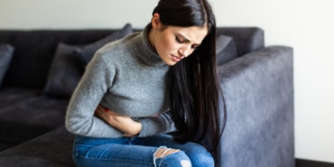 sick-woman-having-stomachache-living-room