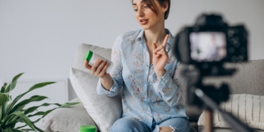 Young woman blogger recording video on camera
