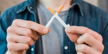 man-s-hand-holding-crossed-cigarettes-1