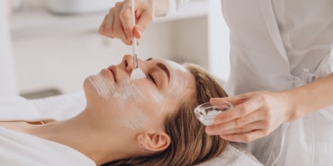 Cosmetologist doing face treatment and applying face mask