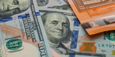 Financial accounting concept with euro and dollar bills high angle view.