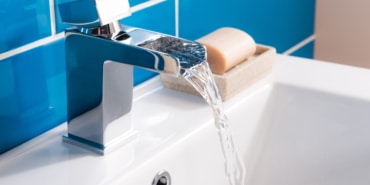 New and modern steel faucet with the ceramic sink in the bathroom