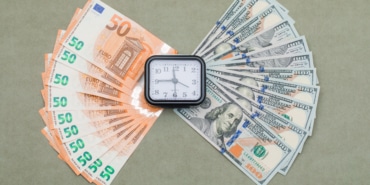 Financial concept with clock, dollar and euro bills on green grey background flat lay.