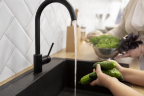 close-up-hands-washing-cucumbers