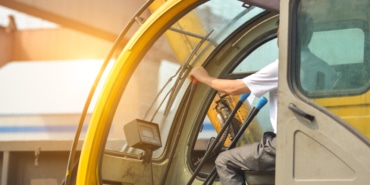 Man driving a crane to lift-up some equipments