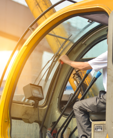 Man driving a crane to lift-up some equipments