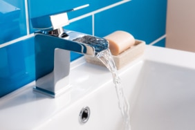 New and modern steel faucet with the ceramic sink in the bathroom