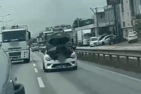 BURSA'DA SEYİR HALİNDEKİ OTOMOBİLİN KAPUTUNU AÇARAK TAMİR YAPTI
