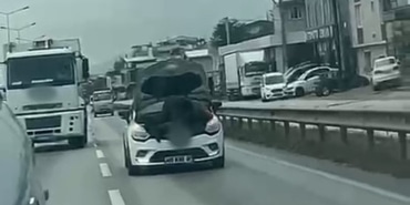 BURSA'DA SEYİR HALİNDEKİ OTOMOBİLİN KAPUTUNU AÇARAK TAMİR YAPTI
